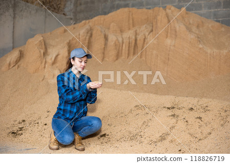 Farmer holding a handful of soybean husks in an animal feed warehouse Farmer holding a handful of soybean husks in an animal feed warehouse 118826719