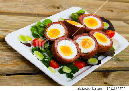 Scotch eggs served with greens and leek, Scottish traditional dish at plate 118826721