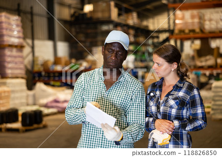 Man and woman working in warehouse, discussing documents 118826850