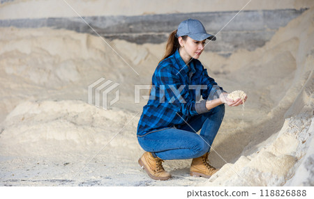 Woman farmer holding handful of corn flour, in animal food storage Woman farmer holding handful of corn flour, in animal food storage 118826888