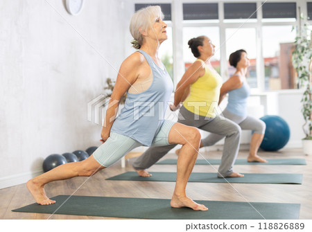 Group of elderly woman doing yoga on mat in studio Group of elderly woman doing yoga on mat in studio 118826889