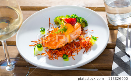 Tasty fried salmon on a pillow of smoked carrots, broccoli and fig on plate 118826900