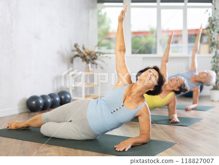 Group of elderly woman doing pilates on mat in studio Group of elderly woman doing pilates on mat in studio 118827007