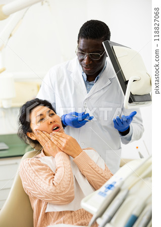 Asian woman with toothache sitting in chair at dentist appointment Asian woman with toothache sitting in chair at dentist appointment 118827068