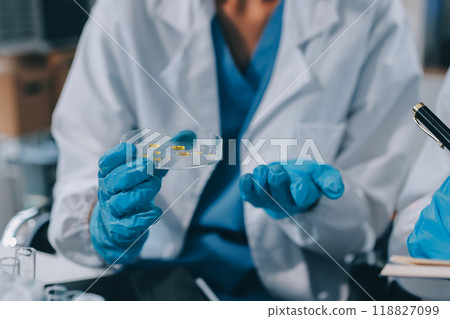 Scientist using microscope in laboratory. Close-up of a researcher's hands adjusting a modern microscope in a lab setting. Science concept Scientist using microscope in laboratory. Close-up of a researcher's hands adjusting a modern microscope in a lab setting. Science concept 118827099
