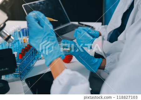Scientist using microscope in laboratory. Close-up of a researcher's hands adjusting a modern microscope in a lab setting. Science concept 118827103
