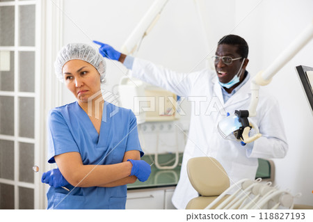 Angry dentist shouting at woman assistant in office of dental clinic Angry dentist shouting at woman assistant in office of dental clinic 118827193