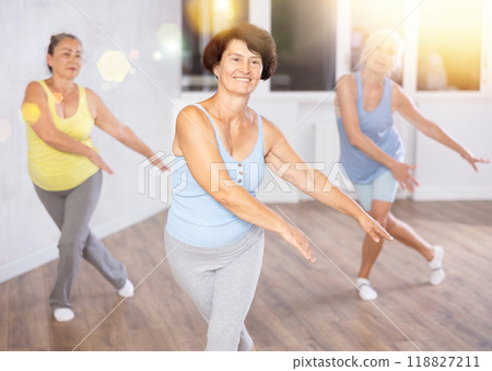 Three elderly women are learning sports Latin American dances in studio class Three elderly women are learning sports Latin American dances in studio class 118827211