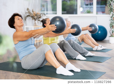 Group of elderly woman doing pilates with soft ball in studio Group of elderly woman doing pilates with soft ball in studio 118827266