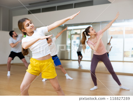 Girl exercising during family dance class Girl exercising during family dance class 118827289