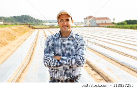 Portrait of positive farmer on field Portrait of positive farmer on field 118827295