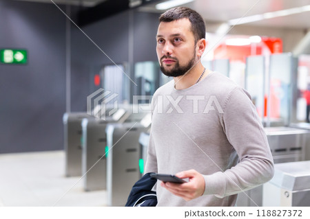 Male passenger in casual clothing near baffle gate in underground platform closeup 118827372