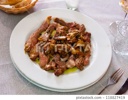 Sliced Italian tagliata with garnish of fried porcini mushrooms 118827419