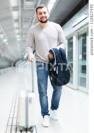 Portrait of confident male passenger in casual clothing on underground platform Portrait of confident male passenger in casual clothing on underground platform 118827430