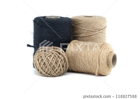 Collection of jute and twine spools on a white background, highlighting natural fiber materials 118827588