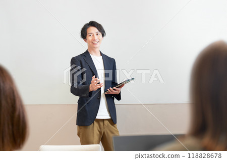 A man giving a lecture in front of a whiteboard 118828678