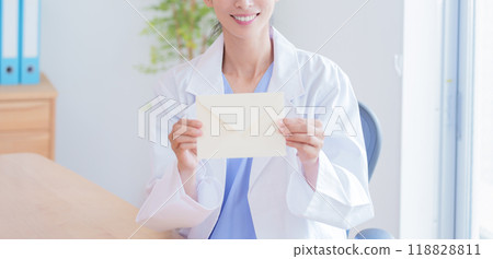Female doctor holding a letter Female doctor holding a letter 118828811