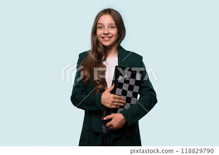 Teen girl smiling while holding a chessboard 118829790