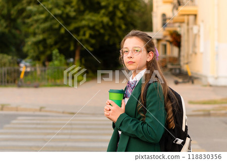 Young girl in green blazer holding green cup 118830356