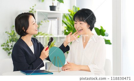 Beauty advisor, middle-aged woman receiving makeup advice Beauty advisor, middle-aged woman receiving makeup advice 118830471