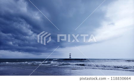 A solitary lighthouse stands in the ocean 118830664