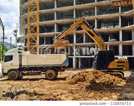 Excavator loads ground into a dump truck at a construction site 118830713