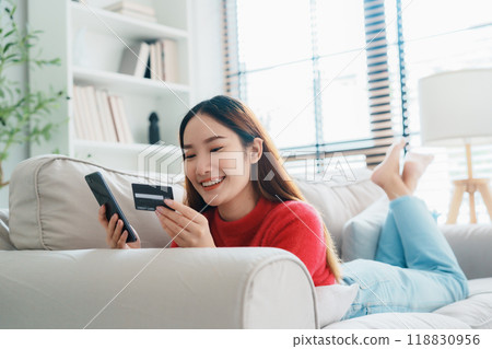 Young asian woman lying on sofa in living room 118830956