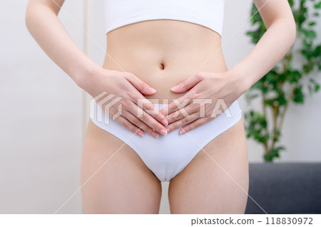 Diseases unique to women, worries, diagnosis, lower abdomen, PMS, woman holding her stomach with both hands 118830972