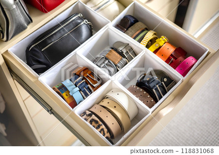 A drawer in a wardrobe with fashionable belts and accessories neatly arranged. Concept of storage 118831068