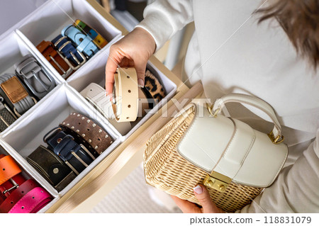 A young woman chooses a belt for a fashionable, trendy summer bag. Concept for storing accessories 118831079