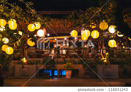 Yellow glowing Chinese lanterns decorate the exterior of cafe in Vietnam in Asia 118831243