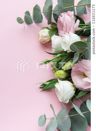 A beautiful arrangement of pastel flowers and eucalyptus leaves on a soft pink background showcasing their vibrant colors and textures 118831275