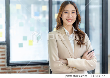 Happy young business woman smiling at camera from her office desk 118831540