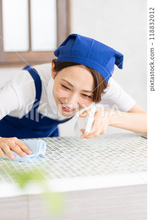 A woman from a housekeeping service cleaning the kitchen A woman from a housekeeping service cleaning the kitchen 118832012