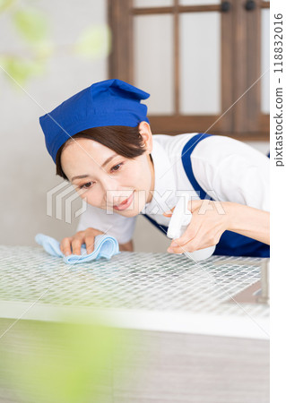 A woman from a housekeeping service cleaning the kitchen 118832016