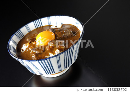 Tsukimi beef curry bowl photographed against a black background Tsukimi beef curry bowl photographed against a black background 118832702