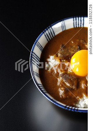 Tsukimi beef curry bowl photographed against a black background 118832726