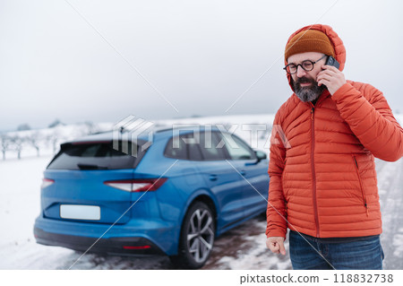 Angry man standing by electric car, battery run out of power before reaching destination. Man phone calling for help waiting for breakdown service car, tow truck. Angry man standing by electric car, battery run out of power before reaching destination. Man phone calling for help waiting for breakdown service car, tow truck. 118832738