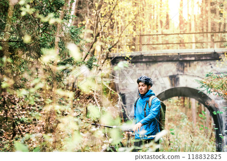 Young man resting by bike in the middle of beautiful nature, early autumn morning. Concept of healthy lifestyle. 118832825