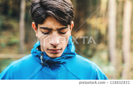 Portrait of male runner resting after jog in nature on dirt running trail. Morning running training for young man. Portrait of male runner resting after jog in nature on dirt running trail. Morning running training for young man. 118832831