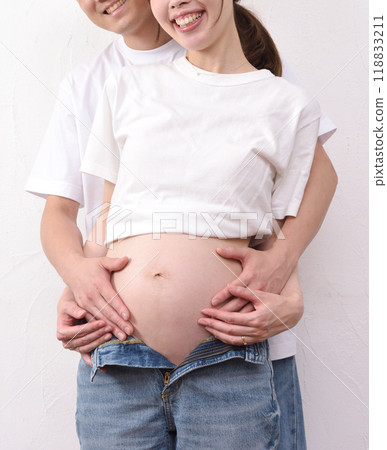 A young pregnant woman with a big belly and her husband 118833211