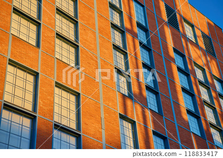 Modern brick office buildings against blue sky. Architectural detail of modern office buildings. Contemporary minimalist architecture Modern brick office buildings against blue sky. Architectural detail of modern office buildings. Contemporary minimalist architecture 118833417