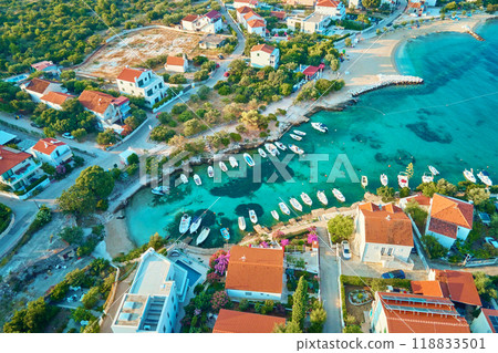 Birds eye view of sea coast with small town along seashore. Aerial top view of coastal village with red-roofed houses and boats near shore. Tourist town Rogoznica in Croatia on Adriatic Sea Birds eye view of sea coast with small town along seashore. Aerial top view of coastal village with red-roofed houses and boats near shore. Tourist town Rogoznica in Croatia on Adriatic Sea 118833501