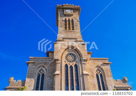 Clock Tower on Nha Trang Cathedral or Stone Church or Christ the King Cathedral in Vietnam against blue sky 118833702