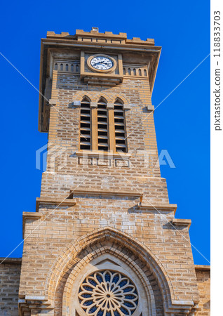 Clock Tower on Nha Trang Cathedral or Stone Catholic Church or Christ the King Cathedral in Vietnam against blue sky background Clock Tower on Nha Trang Cathedral or Stone Catholic Church or Christ the King Cathedral in Vietnam against blue sky background 118833703