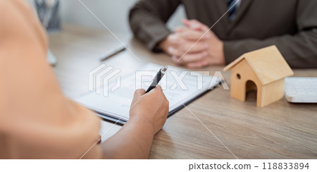 Homebuyer Signing Property Contract with Real Estate Agent Guidance 118833894