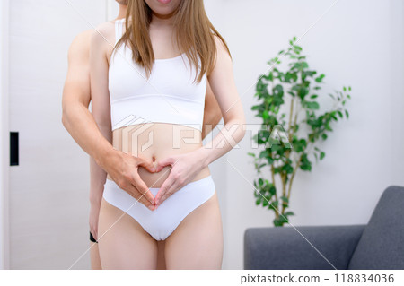 Couple supporting the woman's belly, couple making a heart shape with their hands, married couple, pregnancy support 118834036