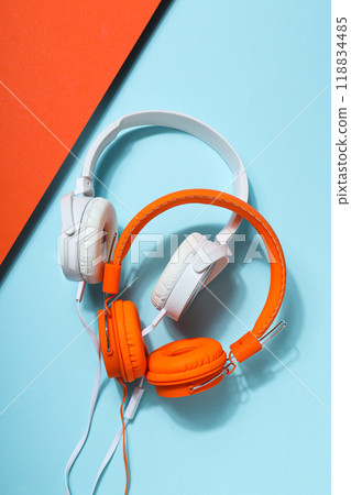 A pair of over-the-ear headphones on a light background. A pair of over-the-ear headphones on a light background. 118834485