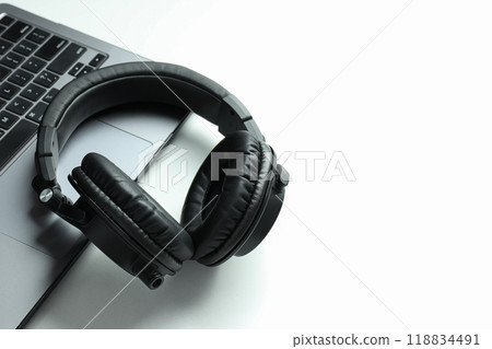 Big headphones, on a table with a laptop. 118834491