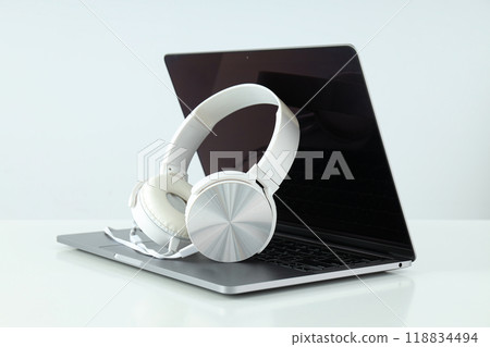 Big headphones, on a table with a laptop. 118834494